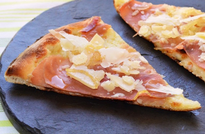 Pizza con cebolla, jamón y parmesano.